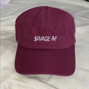 Burgundy “SAVAGE AF” adjustable strapback cap.